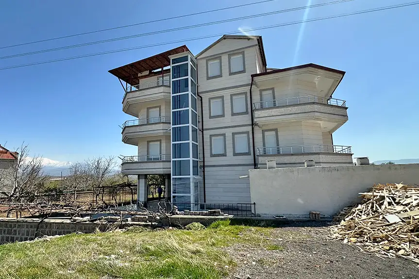 Dış mekânda kullanılan engelli asansörü – cam kaplamalı, sessiz çalışma